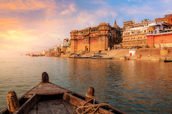Arquitetura antiga da cidade de Varanasi ao pôr do sol, vista de um barco no rio Ganges.