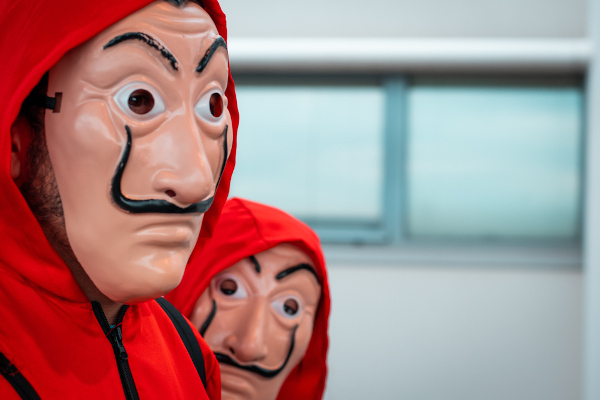 Homens fantasiados com máscara de personagens da série La Casa de Papel, uma das principais fantasias do Halloween. 