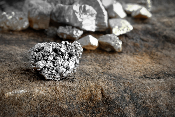 Pedaços de prata, um exemplo de recurso mineral metálico, sobre um piso de pedra.