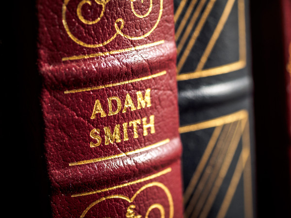 Vista aproximada da lombada de um livro de Adam Smith, um dos principais pensadores do liberalismo econômico.