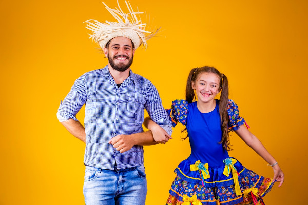 Pai e filha usando roupas de quadrilha, típicas das Festas Juninas. 