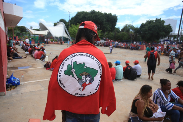 Pessoa com uma bandeira do MST - Movimento dos Trabalhadores Rurais Sem Terra.