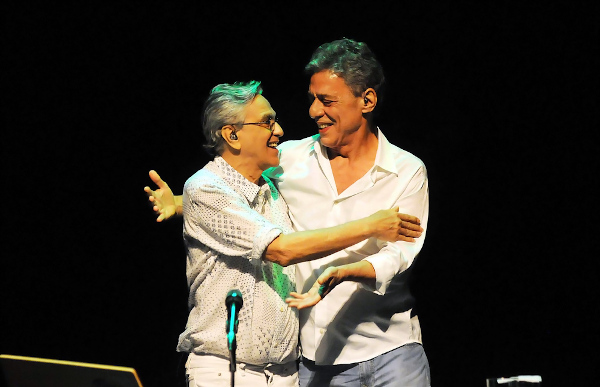 Caetano Veloso e Chico Buarque, dois dos principais artistas da música popular brasileira (MPB), abraçados durante um show.