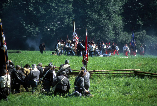 Soldados confederados prontos para atirar contra o avanço da União, em reconstituição de uma batalha da Guerra de Secessão.