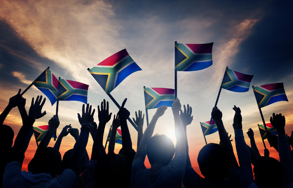 Grupo de pessoas com bandeiras sul-africanas, um dos elementos presentes na cultura da África do Sul.