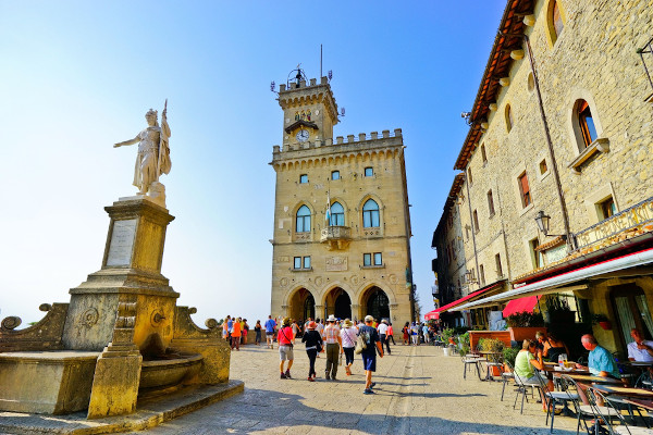 Turistas caminhando em frente ao Palácio Público, em San Marino.