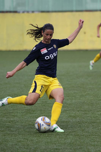Marina Aggio, mulher branca atlética jogando bola em campo