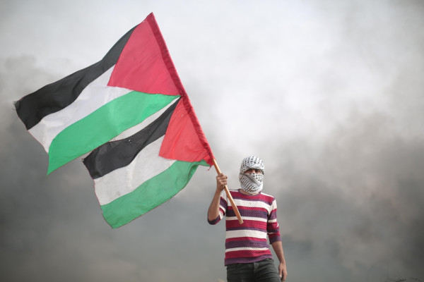 Homem segura bandeira palestina.