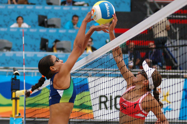 Jogadoras de vôlei próximas à rede durante partida de vôlei de areia no Jogos Pan-Americanos 2007.