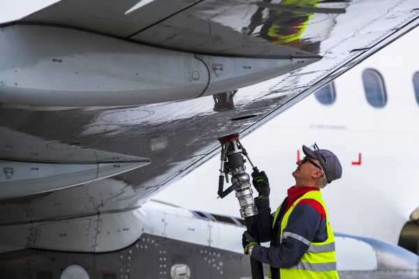 Homem abastecendo avião com querosene, o principal combustível utilizado nos aviões.