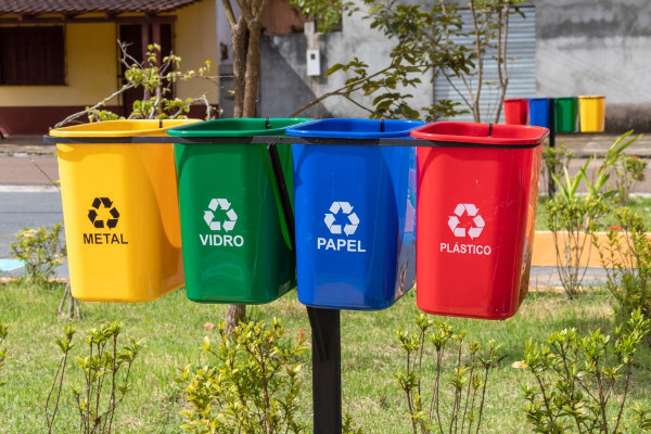 Coletores de lixo com as quatro principais cores da coleta seletiva.