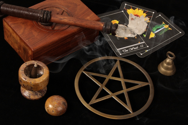 Cartas de tarô, bastão, tarô e pentagrama usados na religião Wicca.