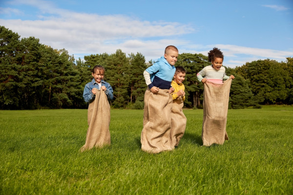  Crianças brincando de corrida no saco, uma das brincadeiras juninas.