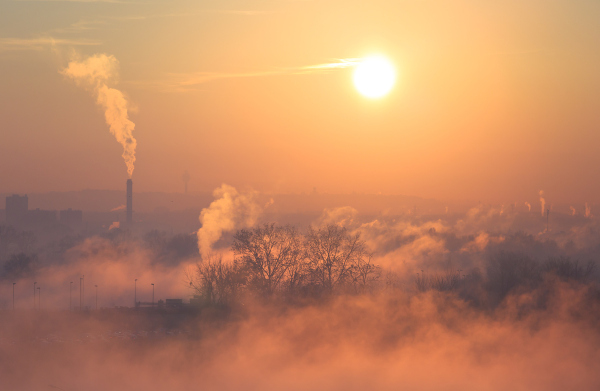 Nuvem de poluição de fábricas sobre uma cidade, em texto sobre acordos climáticos.
