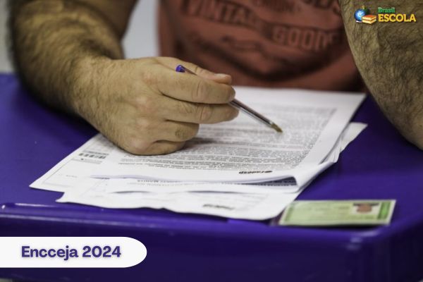 Candidato em dia de prova com caderno do Encceja na mesa