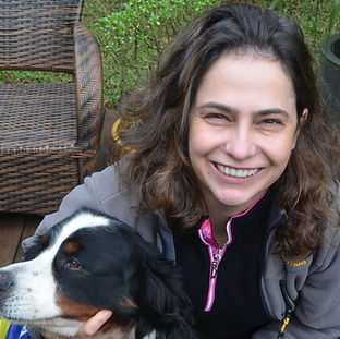 Márcia Marques está sorrindo na foto ao lado de um cachorro