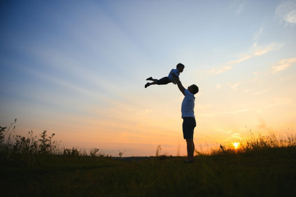 Fotografia de pai brincando com o filho em alusão ao Dia dos Pais, uma das datas comemorativas de agosto.