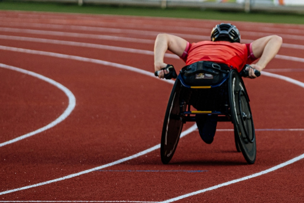 Atleta com cadeira de rodas em pista de atletismo, um dos esportes paralímpicos.