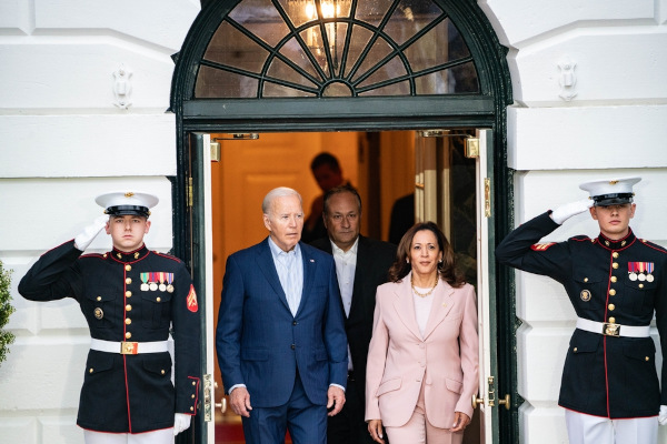 Joe Biden e Kamala Harris entre dois guardas.