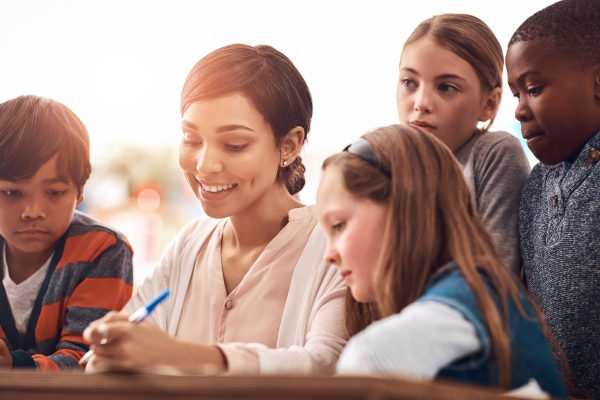 Professora e estudantes crianças ao seu redor