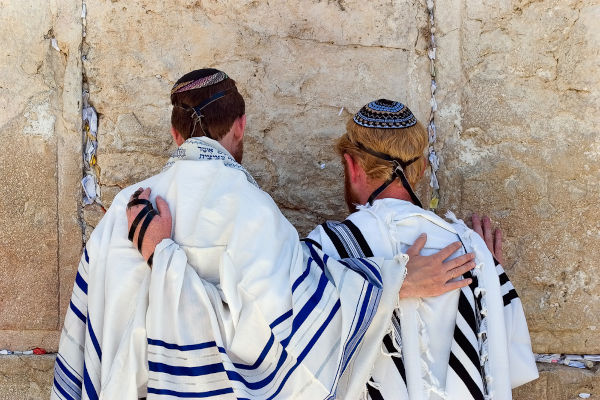 Dois judeus de costas, orando no Muro das Lamentações, em Jerusalém.