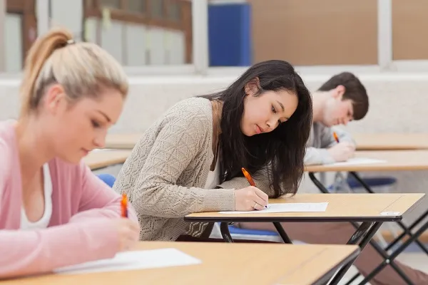 Estudantes na sala de aula escrevendo