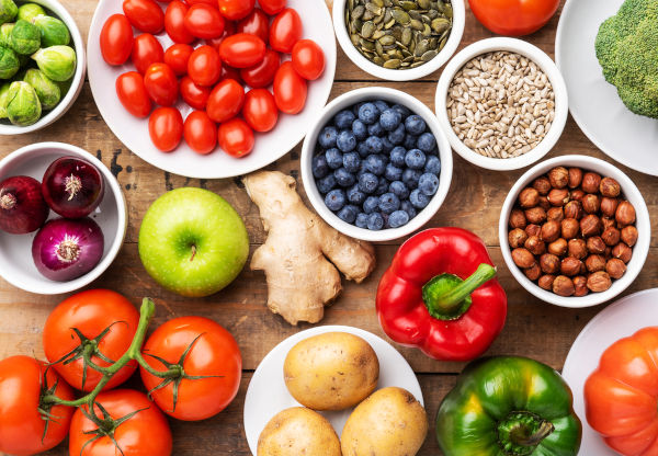Alimentos de origem vegetal sobre uma mesa de madeira. [imagem_principal]