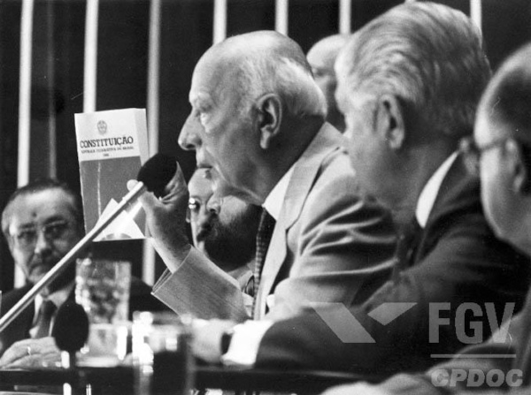 Ulisses Guimarães apresenta o primeiro exemplar da Constituição Federal de 1988 no plenário da Câmara dos Deputados em Brasília (DF).[2]