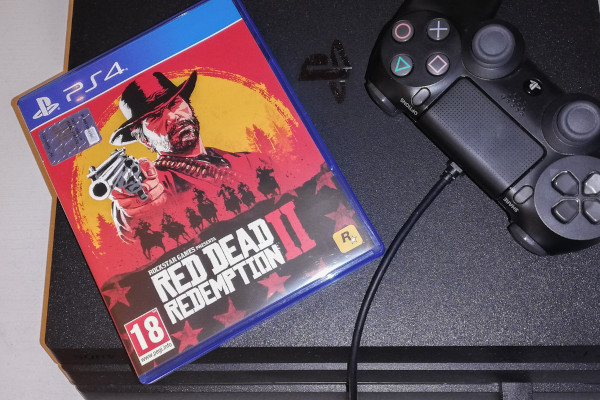 Cóuboi segurando pistola em capa de jogo de Velho Oeste, ao lado de um controle de Playstation.