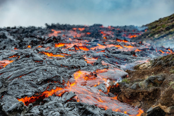 Lava recobrindo superfície terrestre, o que origina as rochas ígneas.