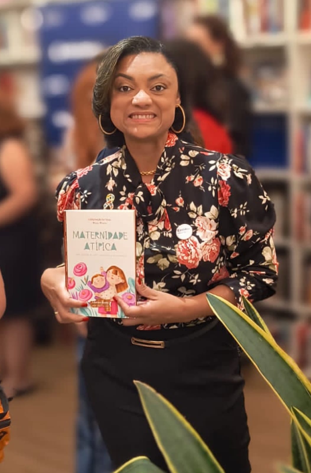 Vanessa Azevedo segurando seu livro sobre maternidade atípica