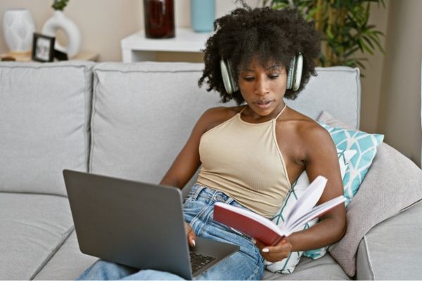 Mulher estuda com fones de ouvido em alusão ao estudo para o Enem com podcasts.