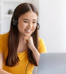 Estudante com fone de ouvido sentando em frente a notebook
