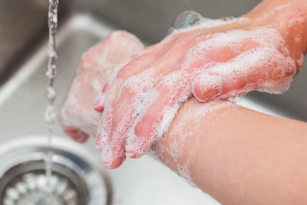 Lavar as mãos com água e sabão é essencial para retirar sujeiras visíveis.