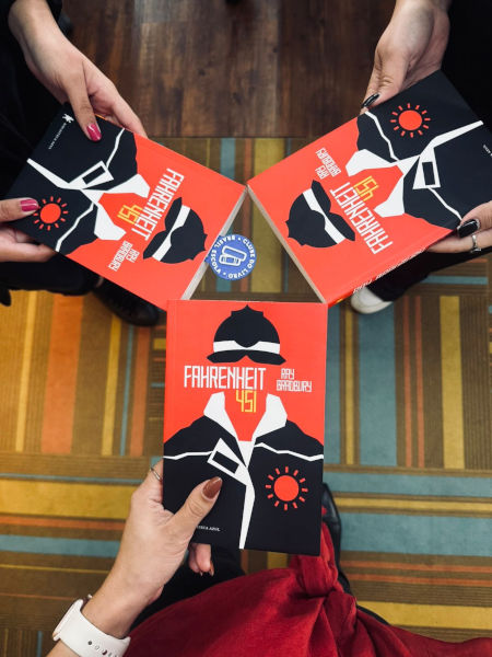 Tr&ecirc;s m&atilde;os seguram tr&ecirc;s livros &ldquo;Fahrenheit 451&rdquo;.
