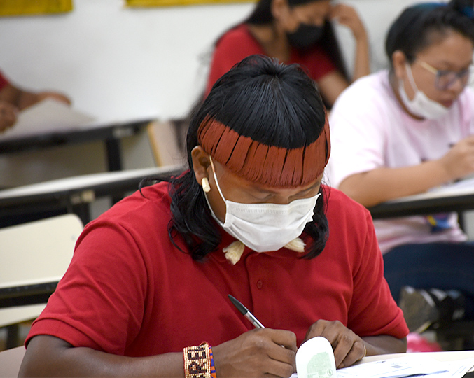 Homem indígena com máscara fazendo prova de vestibular da Unicamp