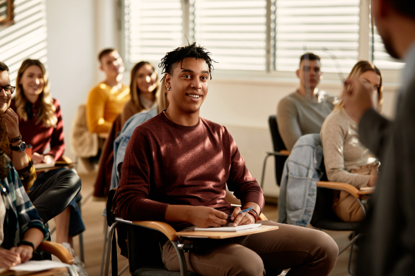 estudantes em sala de aula. Em destaque, aluno negro.