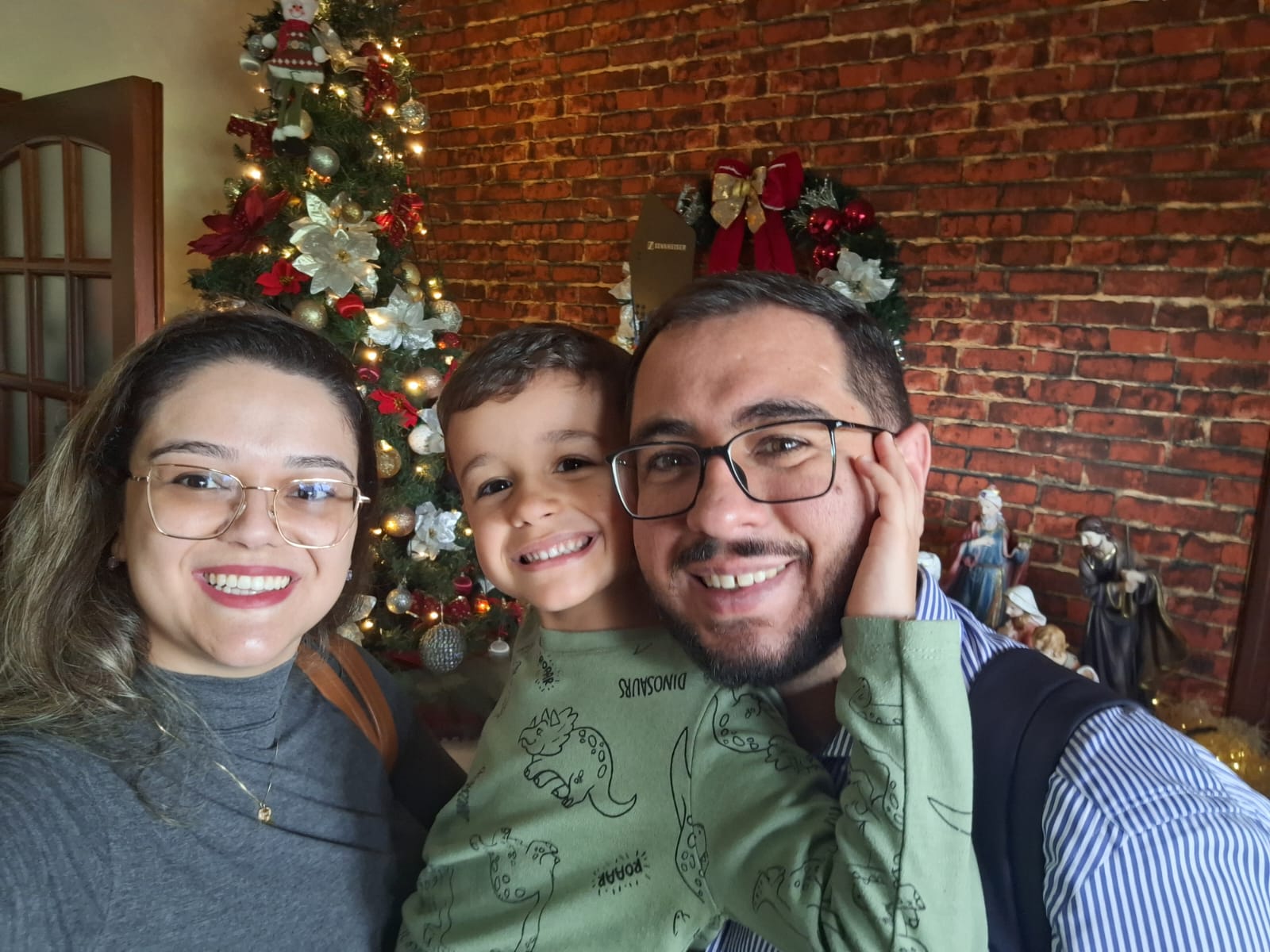 Amanda, Osmar e Luís Henrique em sala decorada de Natal